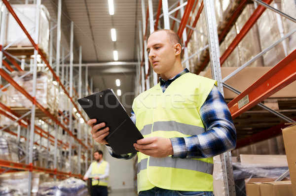 Stock photo: man with clipboard in safety vest at warehouse