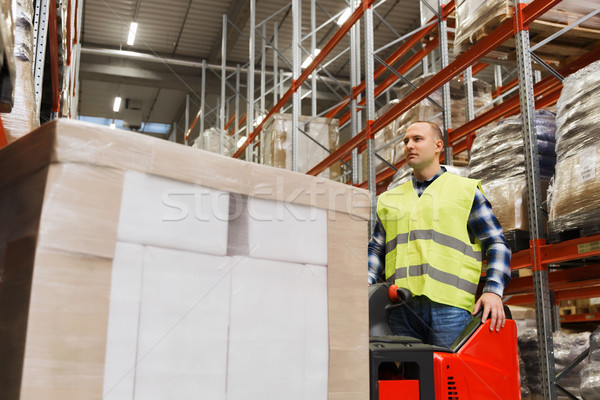 man with tablet pc operating forklift at warehouse Stock photo © dolgachov