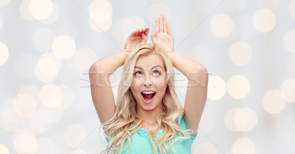 happy smiling young woman making bunny ears Stock photo © dolgachov