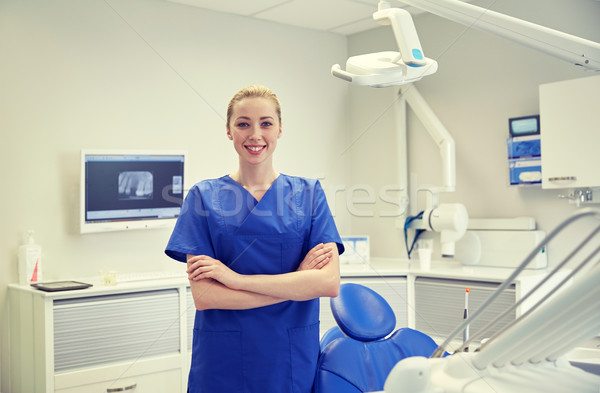 happy young female dentist at dental clinic office Stock photo © dolgachov