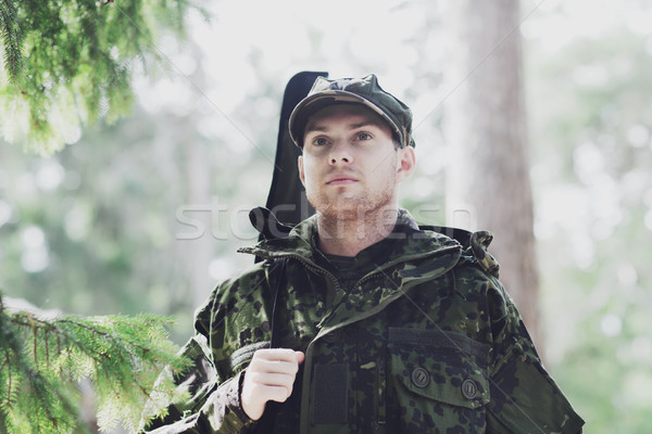 young soldier or hunter with gun in forest Stock photo © dolgachov