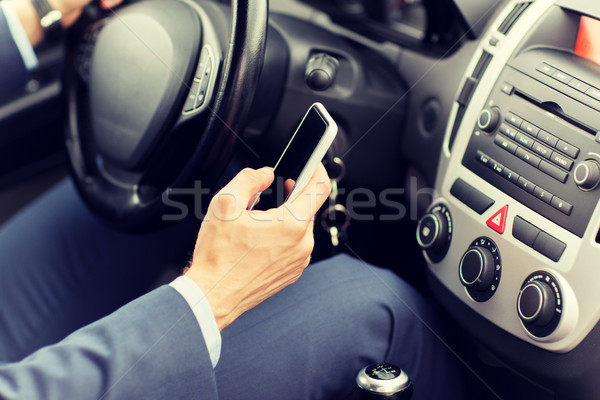 close up of man hand with smartphone driving car Stock photo © dolgachov