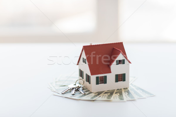 close up of home model, money and house keys Stock photo © dolgachov