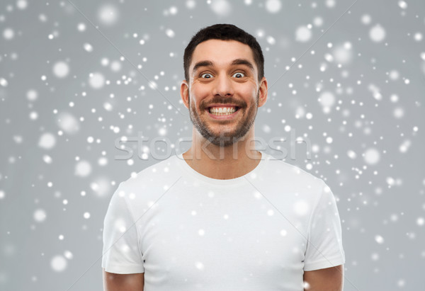 man with funny face over snow Stock photo © dolgachov