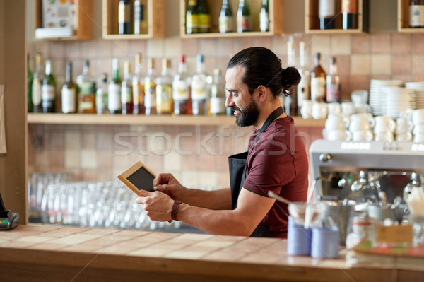 happy man or waiter with chalkboard banner at bar Stock photo © dolgachov