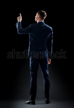 businessman in suit touching something invisible Stock photo © dolgachov