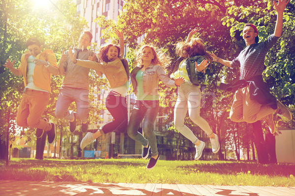 Szczęśliwy studentów znajomych skoki odkryty Zdjęcia stock © dolgachov