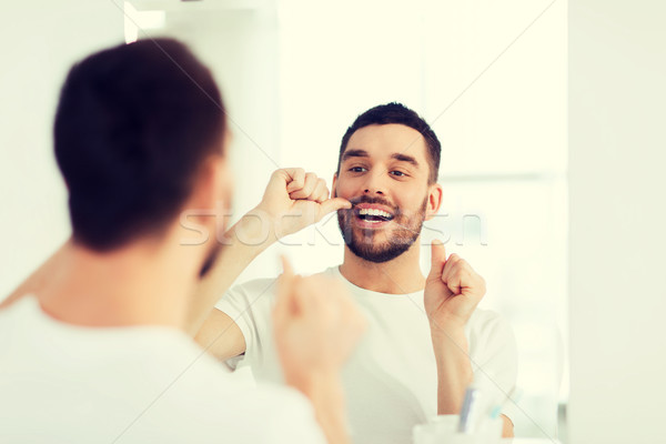 Mann Zahnseide Reinigung Zähne Bad Gesundheitspflege Stock foto © dolgachov