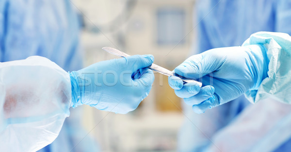 close up of hands with scalpel at operation Stock photo © dolgachov