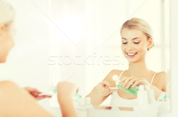 young woman with lotion washing face at bathroom Stock photo © dolgachov