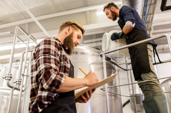 men working at craft brewery or beer plant Stock photo © dolgachov