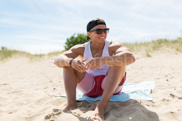 幸せ 笑みを浮かべて 若い男 日光浴 ビーチタオル 夏 ストックフォト © dolgachov