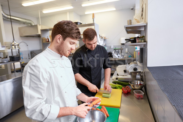 chef and cook cooking food at restaurant kitchen Stock photo © dolgachov