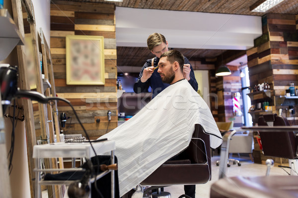man and barber cutting hair at barbershop Stock photo © dolgachov