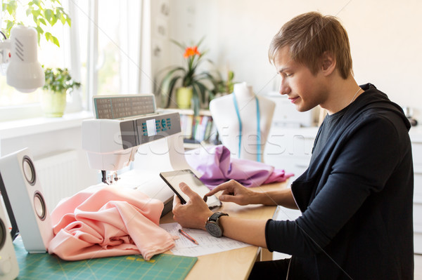 fashion designer with tablet pc working at studio Stock photo © dolgachov