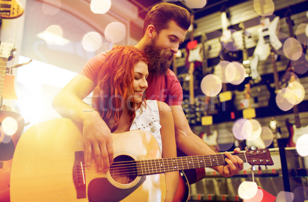 couple of musicians with guitar at music store Stock photo © dolgachov