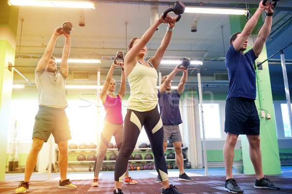 group of people with kettlebells exercising in gym Stock photo © dolgachov