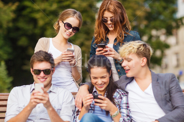 students looking at smartphones and tablet pc Stock photo © dolgachov