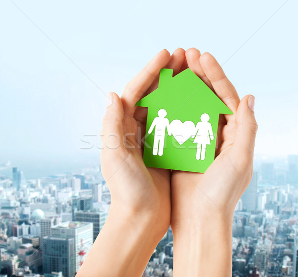 hands holding green house with family Stock photo © dolgachov