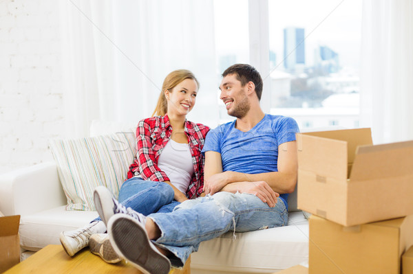 Stock photo: smiling couple relaxing on sofa in new home