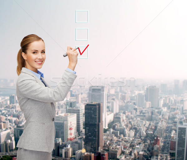 businesswoman writing something in air with marker Stock photo © dolgachov
