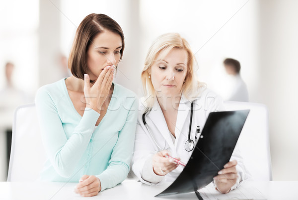 doctor with patient looking at x-ray Stock photo © dolgachov