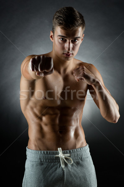 Fiatalember harcol áll fekete sport testépítés Stock fotó © dolgachov