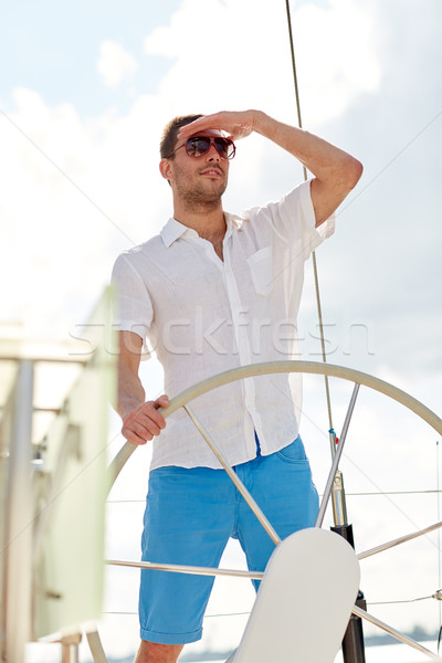 Junger Mann Sonnenbrillen Lenkrad Yacht Urlaub Feiertage Stock foto © dolgachov