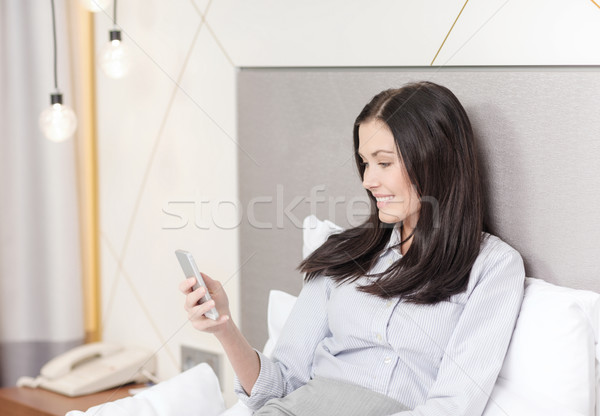 happy businesswoman with smartphone in hotel room Stock photo © dolgachov