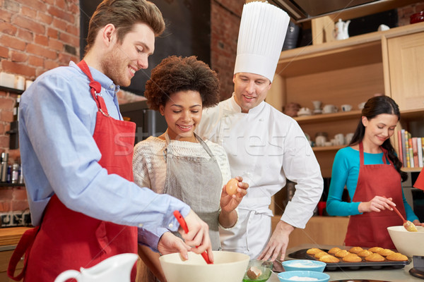 happy friends and chef cook baking in kitchen Stock photo © dolgachov