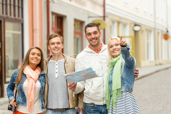 group of smiling friends with map and photocamera Stock photo © dolgachov