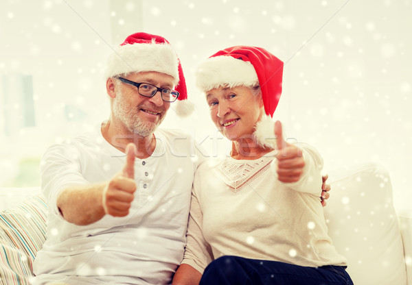 happy senior couple in santa helper hats at home Stock photo © dolgachov