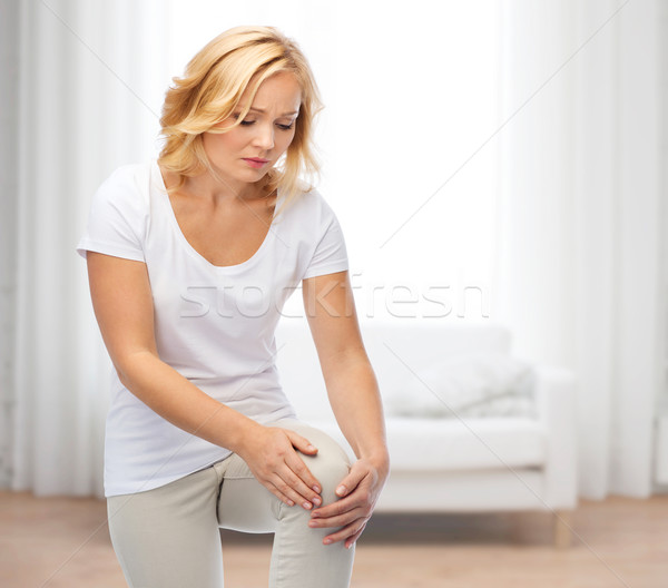 unhappy woman suffering from pain in leg Stock photo © dolgachov