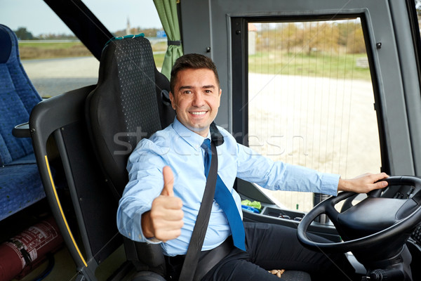 Stock photo: happy driver driving bus and snowing thumbs up