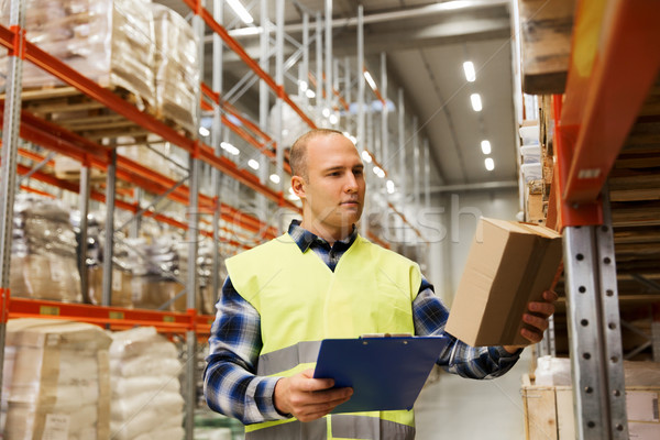 man with clipboard in safety vest at warehouse Stock photo © dolgachov