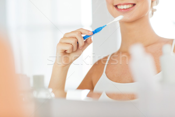 Femme brosse à dents nettoyage dents salle de bain [[stock_photo]] © dolgachov