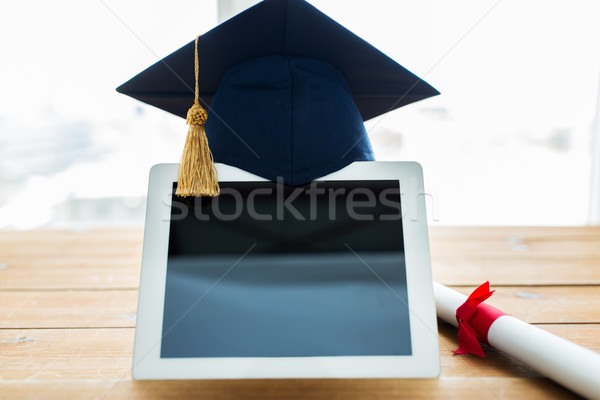 close up of tablet pc with mortarboard and diploma Stock photo © dolgachov