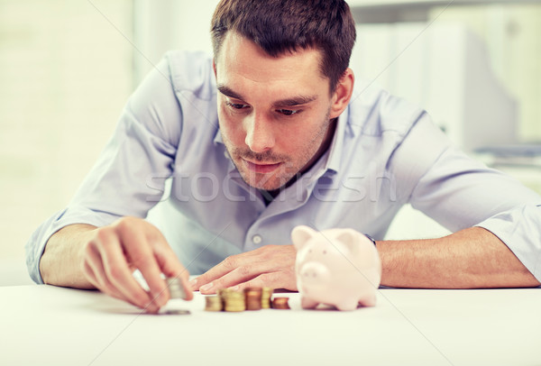 Stock photo: businessman with piggy bank and coins at office