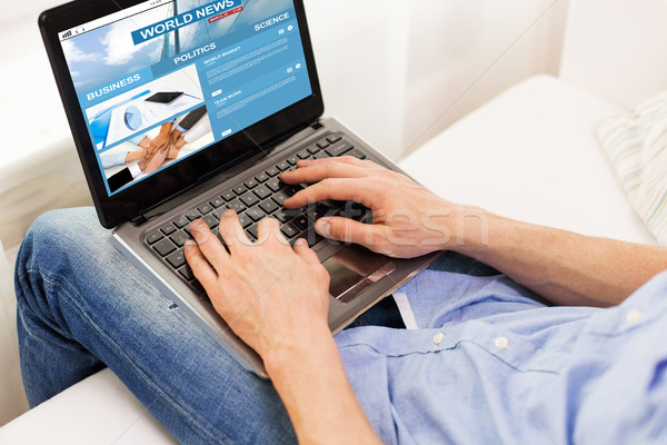 Stock photo: close up of man typing on laptop computer at home