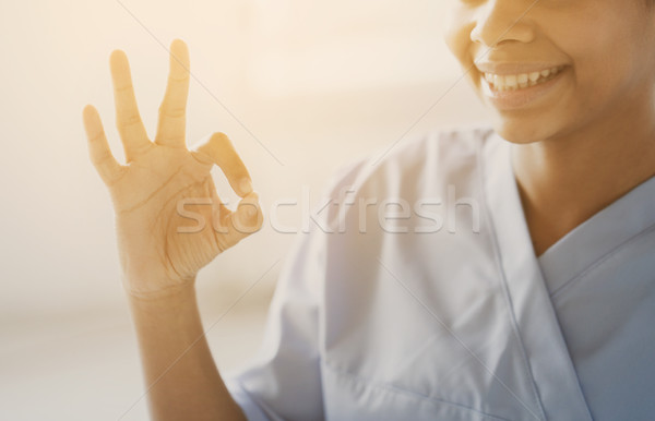close up of african medic or nurse showing ok sign Stock photo © dolgachov
