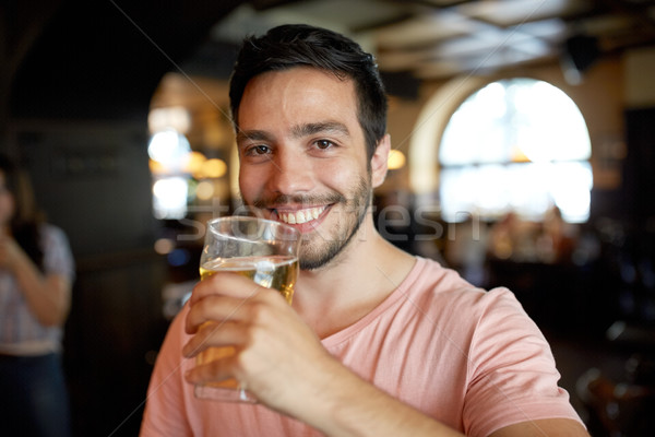 close up of happy man drinking beer at bar or pub Stock photo © dolgachov