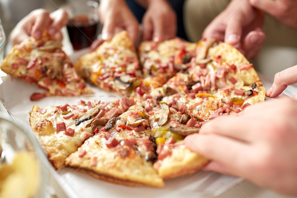 close up of hands taking pizza slices Stock photo © dolgachov