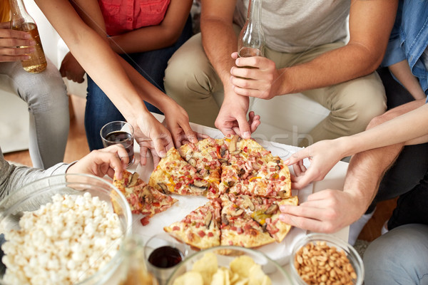 close up of people taking pizza slices at home Stock photo © dolgachov