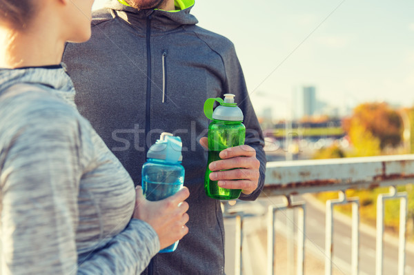 close up of couple with water bottles outdoors Stock photo © dolgachov