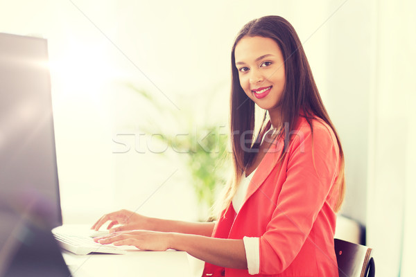 happy african woman with computer at office Stock photo © dolgachov