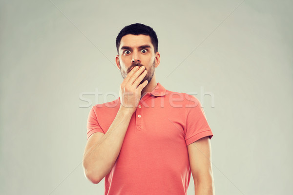 scared man in polo t-shirt over gray background Stock photo © dolgachov