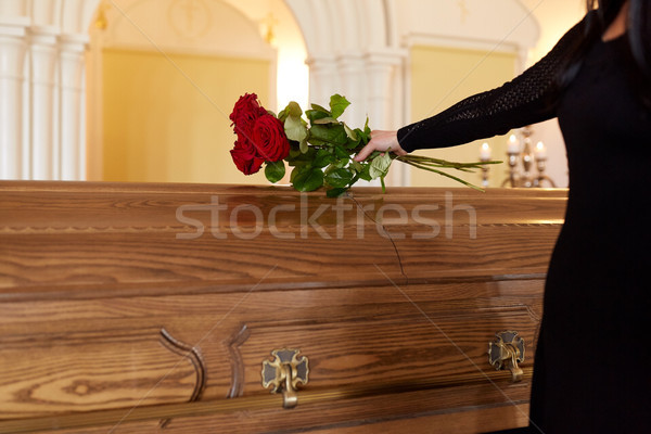 woman with red roses and coffin at funeral Stock photo © dolgachov