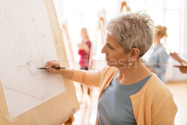 woman artist with pencil drawing at art school Stock photo © dolgachov