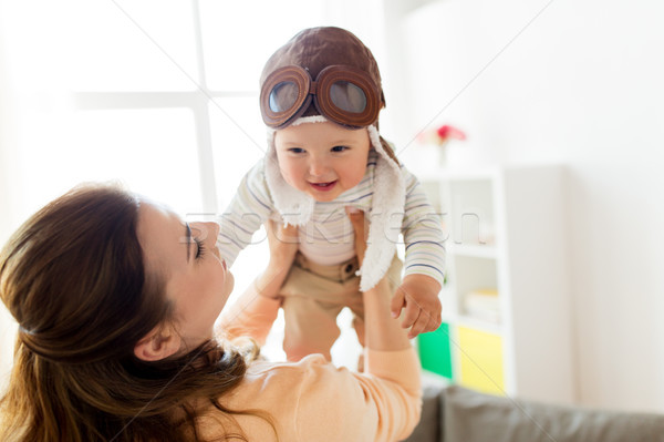 happy mother with baby wearing pilot hat at home Stock photo © dolgachov