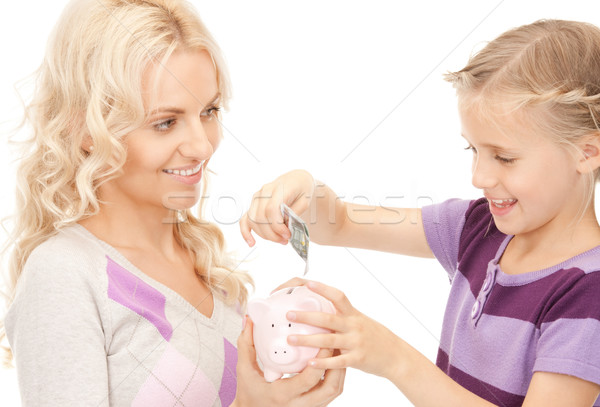 mother and little girl with piggy bank Stock photo © dolgachov